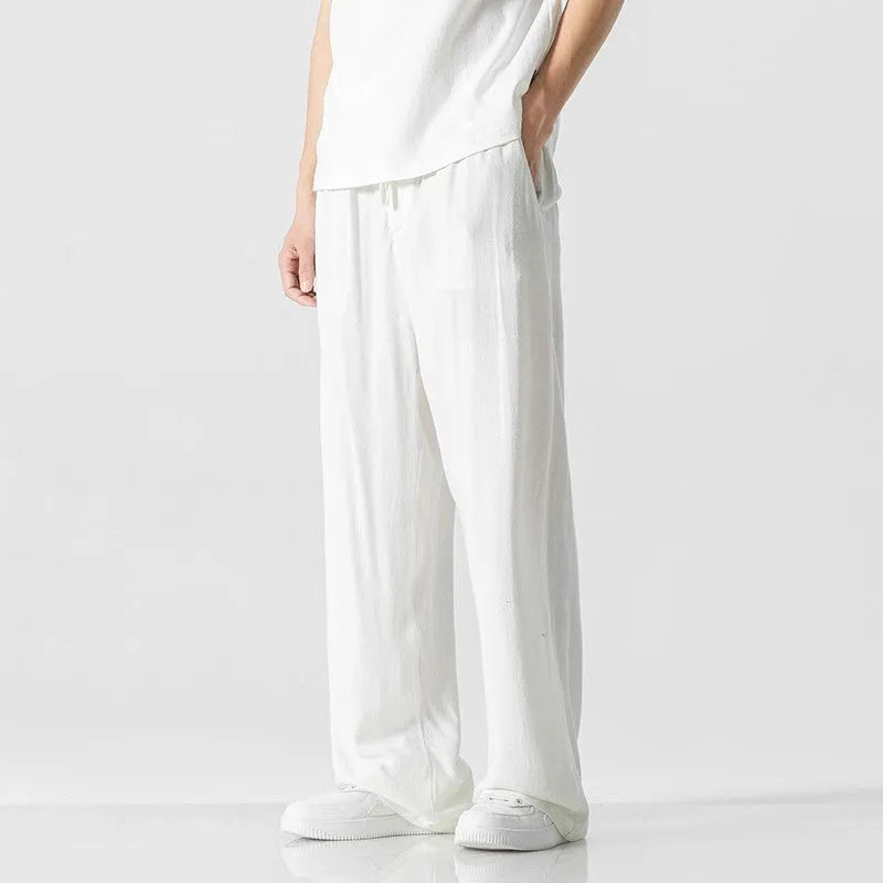 Men's beige bamboo fibre straight-leg cropped trousers with a drawstring waist on a neutral background.