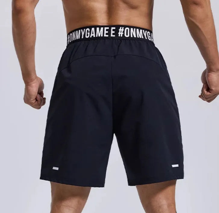 Men's loose black sports shorts with elastic waistband and letter detailing, shown front view.