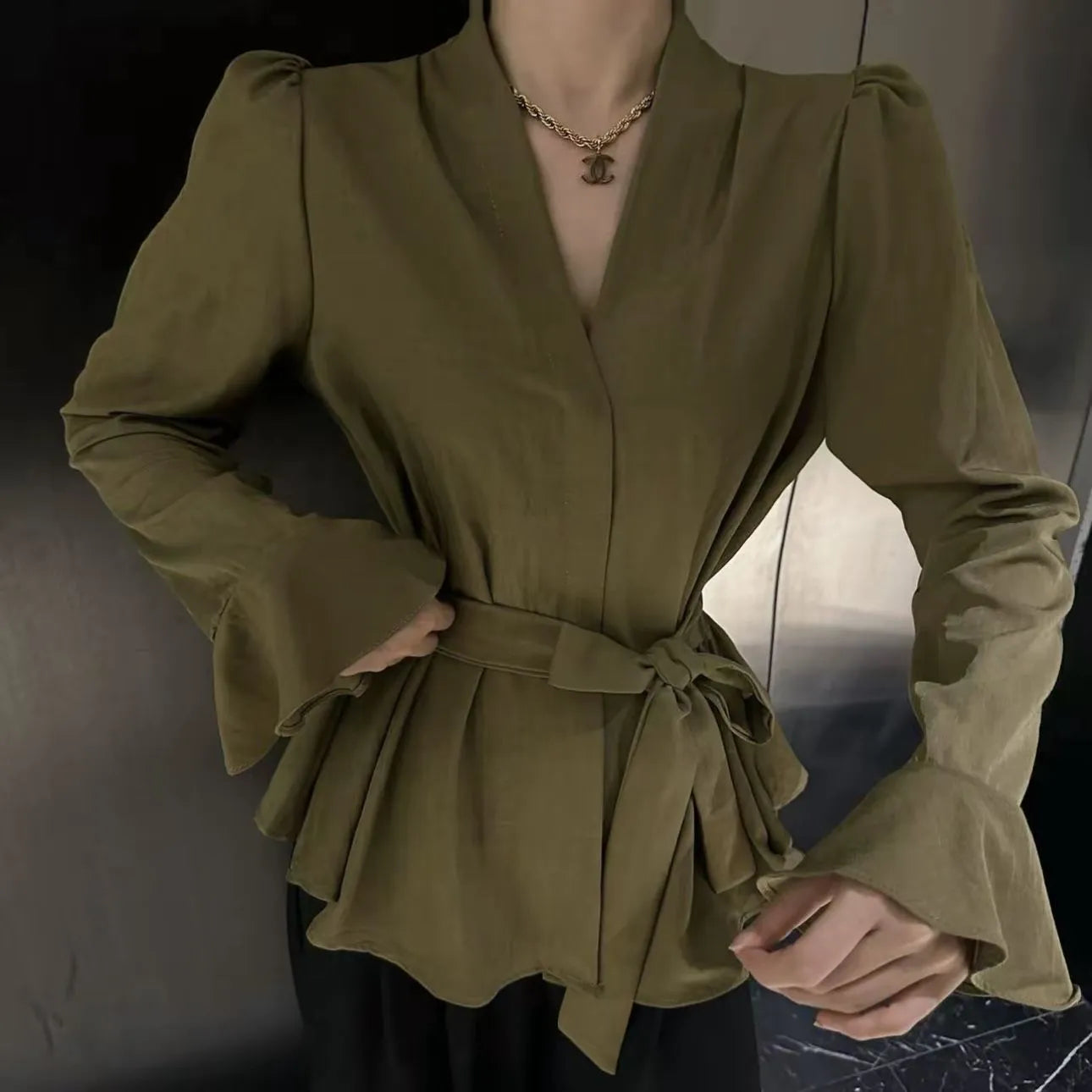 Women's black French-style shirt with irregular collar and tied waist detail featuring bell sleeves