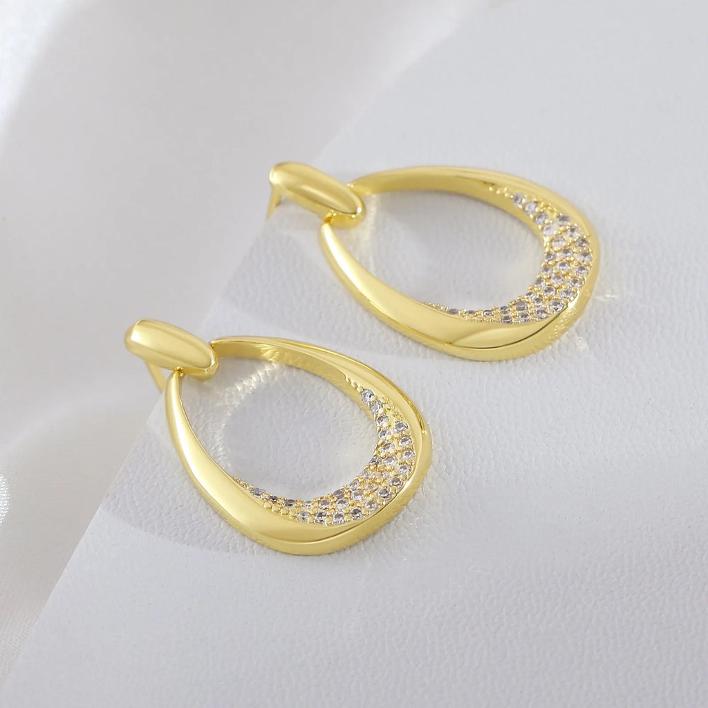 Yellow gold coloured geometric drop earrings for women, showing oval ring design.