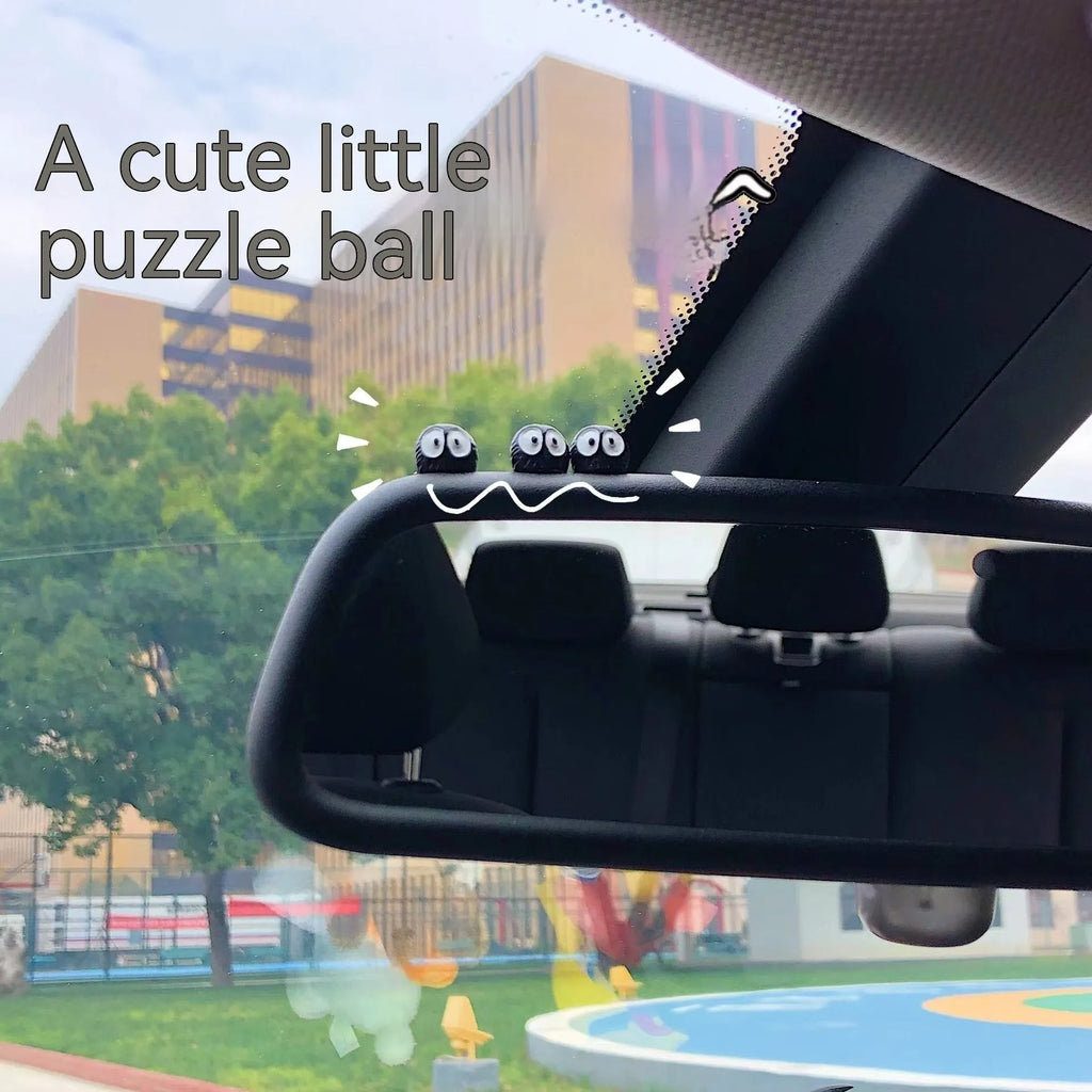 Small black resin cartoon coal briquette decoration next to a roll of traceless tape.