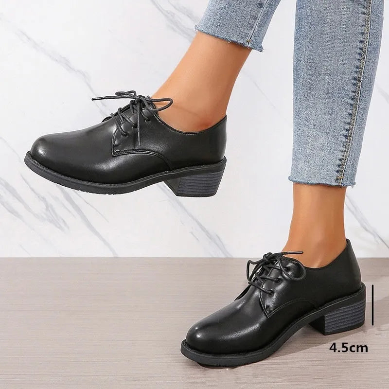 Black women's low-top work shoes with a thick chunky mid-heel and rubber sole.