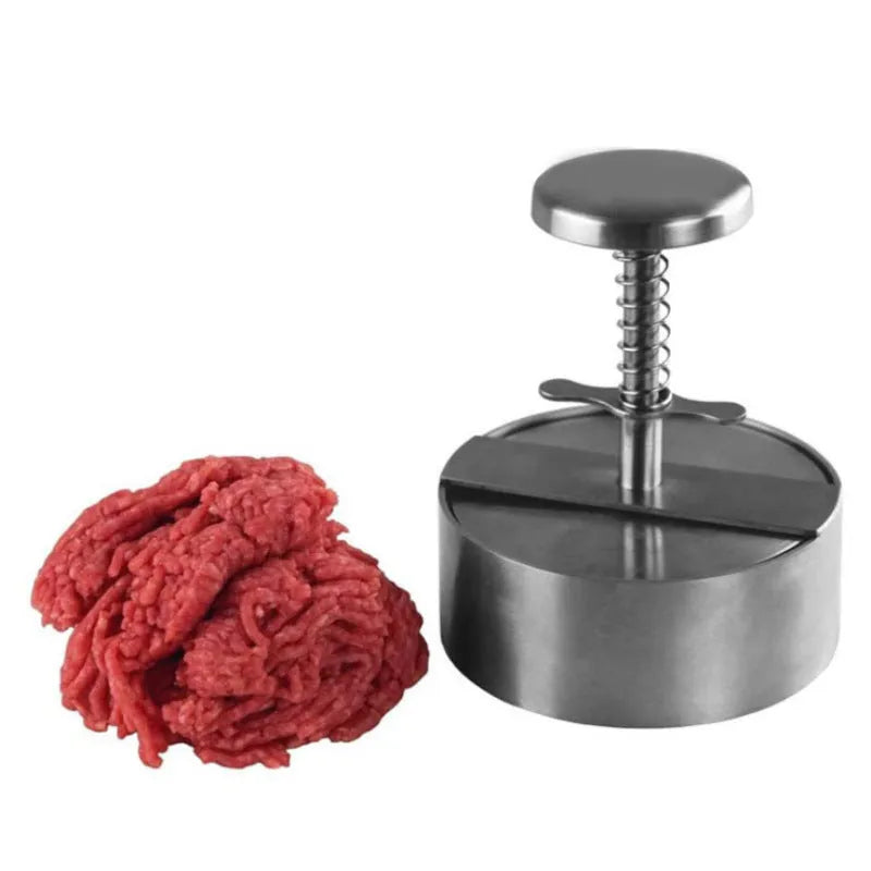 Silver stainless steel patty mould with 14cm diameter on a kitchen counter