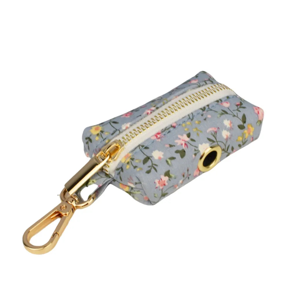 Blue floral patterned cloth dog collar with matching leash and vest set on a white background.