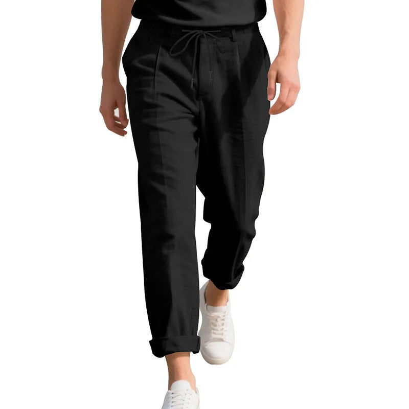 Man wearing light khaki straight-leg linen trousers with a drawstring waist.