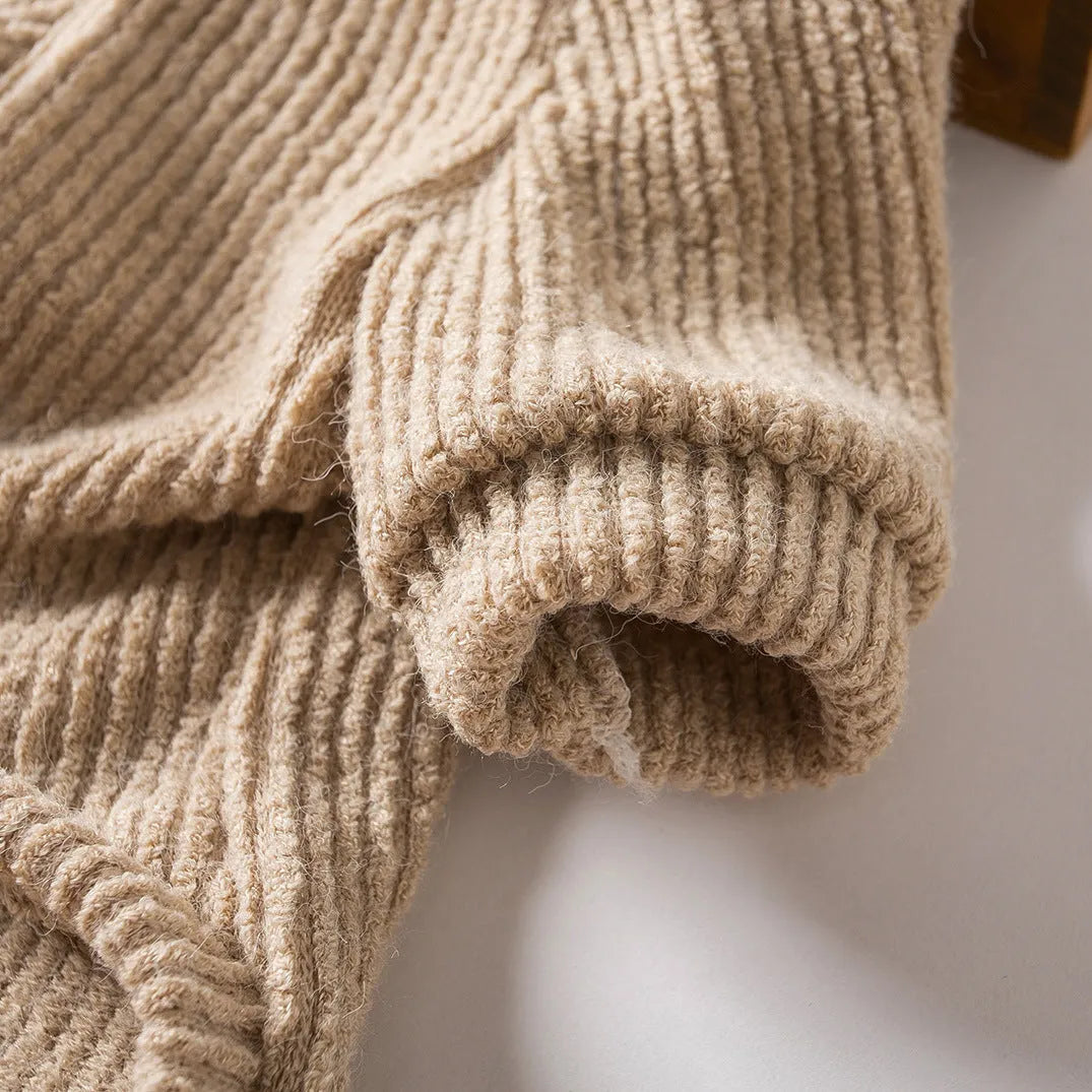 Brown knitted dog sweater on a small white dog, showing a casual pullover style.