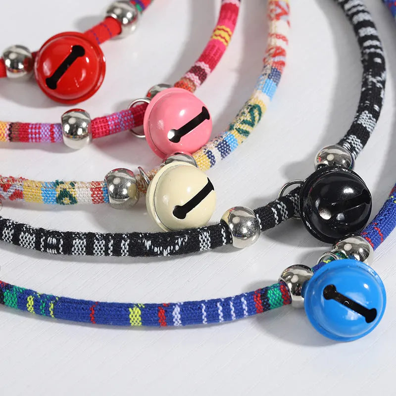 Coloured ethnic pattern adjustable pet collar for dogs and cats with a small metal bell attached.