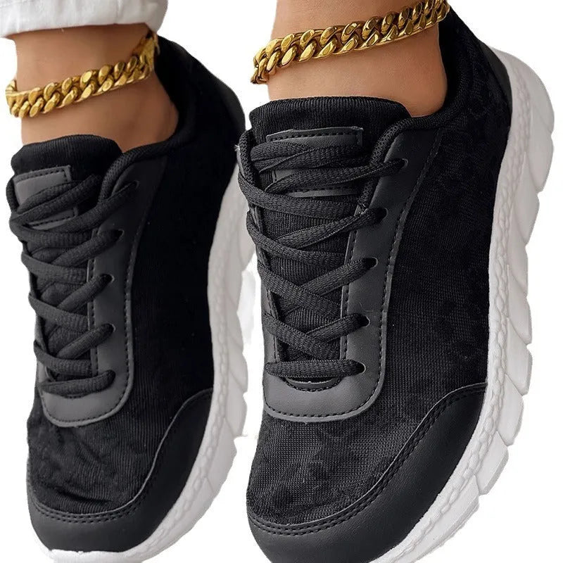 Women's white canvas running shoe with a soft sole and flat heel on a plain background