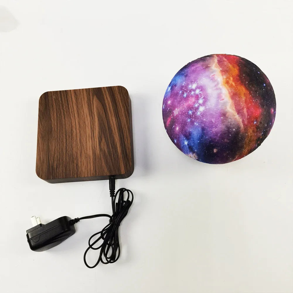 Magnetic levitation galaxy decorative light with rotating moon lamp above walnut-coloured circular base