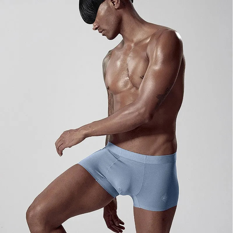 Men's seamless one-piece modal underwear in green, shown flat, highlighting its mid-waist and solid colour design.