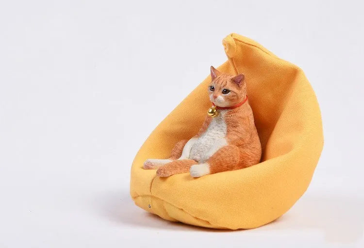 Lazy cat figurine on a small sofa, a 7.5cm tall resin car ornament for dashboard or shelf decoration.