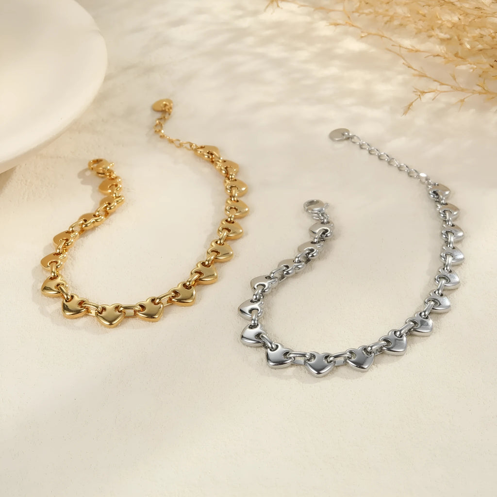 Women's stainless steel bracelet with a hollowed-out heart charm in gold, steel or colour electroplated finish.