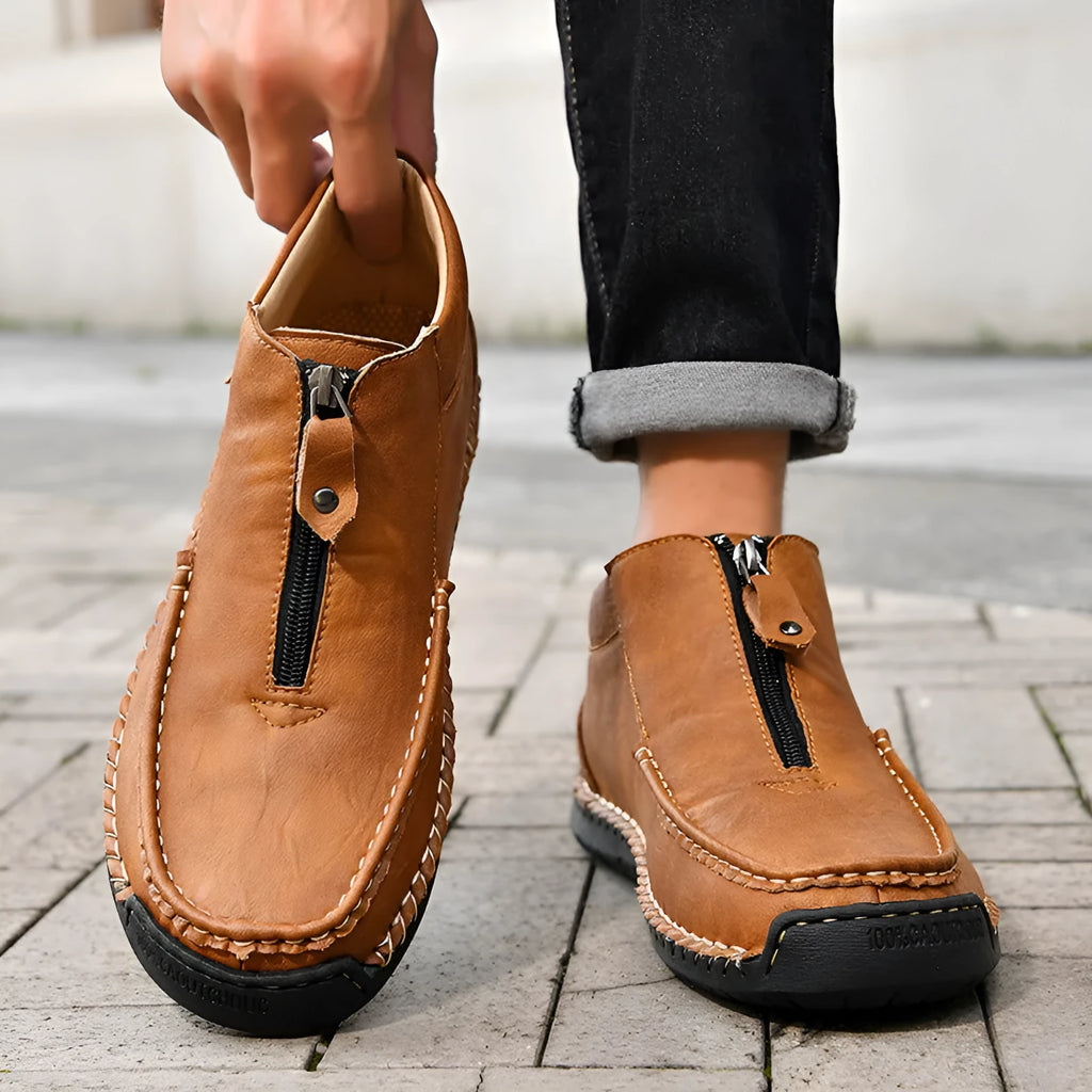Men's black slip-on leather loafers with a round toe and visible stitching on a sewn rubber sole.