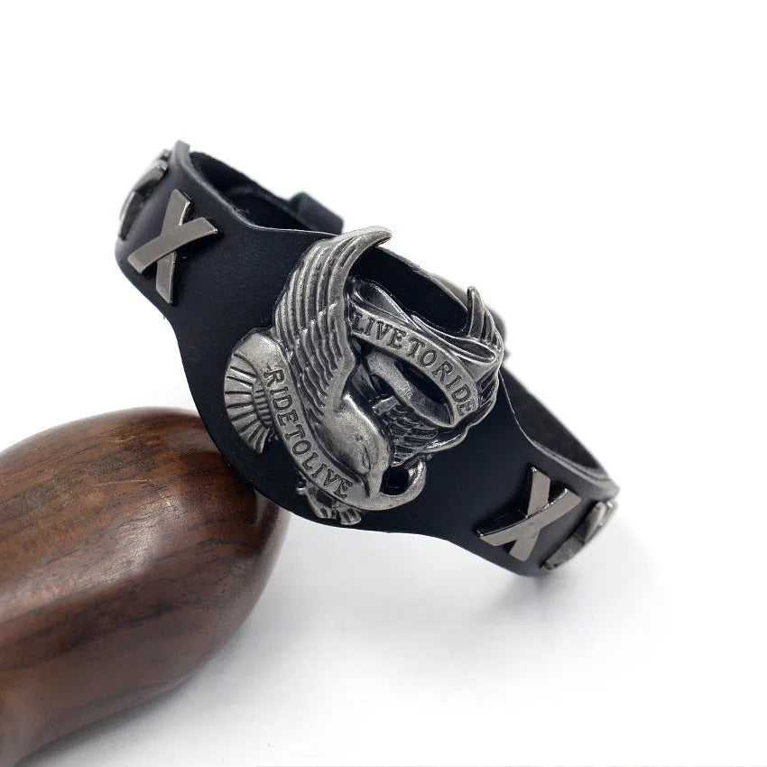 Black geometric leather bracelet with a detailed alloy eagle watch-button clasp on a wrist.