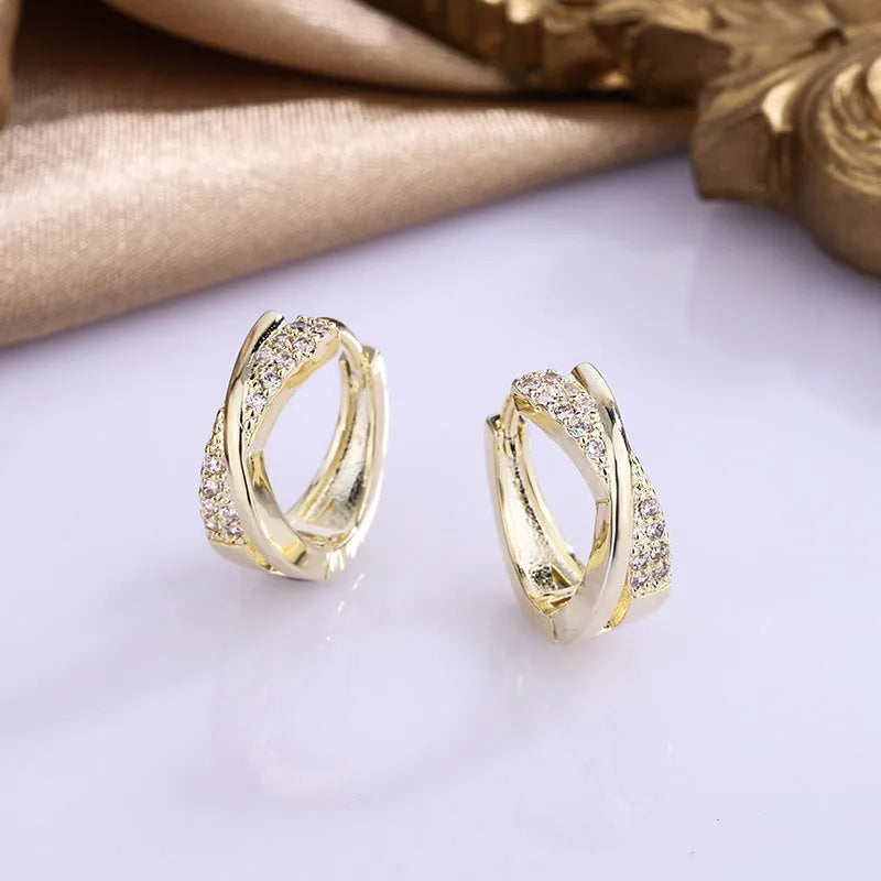 A pair of geometric-shaped copper earrings with a zircon-treated 14K yellow finish.