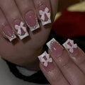 Short white French false nails with bow and tulip designs on a European square shape.