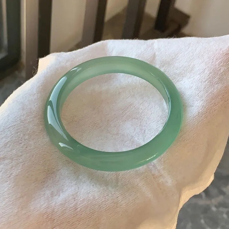 A natural agate wide tyre bracelet showing one of six colour options, such as pink or blue agate, on a wrist.