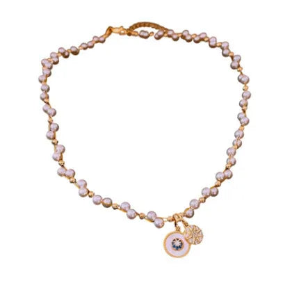 Gold electroplated necklace with zircon and imitation pearl pendant on an adjustable clavicle chain.