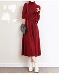 Loose-fit turtleneck knit dress for women with long sleeves, elastic waist, and a flowing mid-length princess skirt.