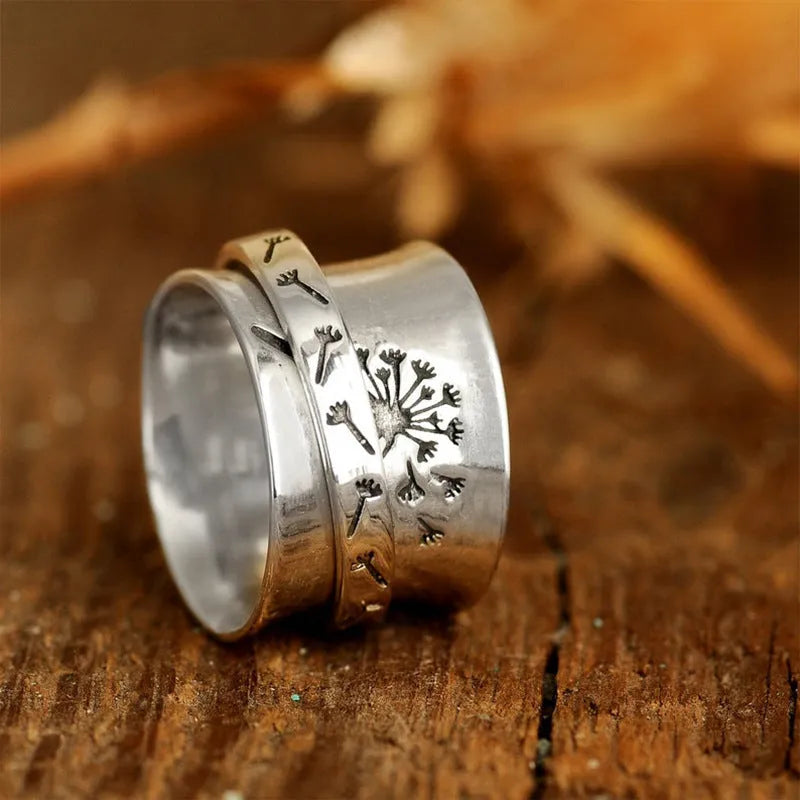 Silver coloured rotatable floral fashion ring on a hand, showing the spinning flower design.