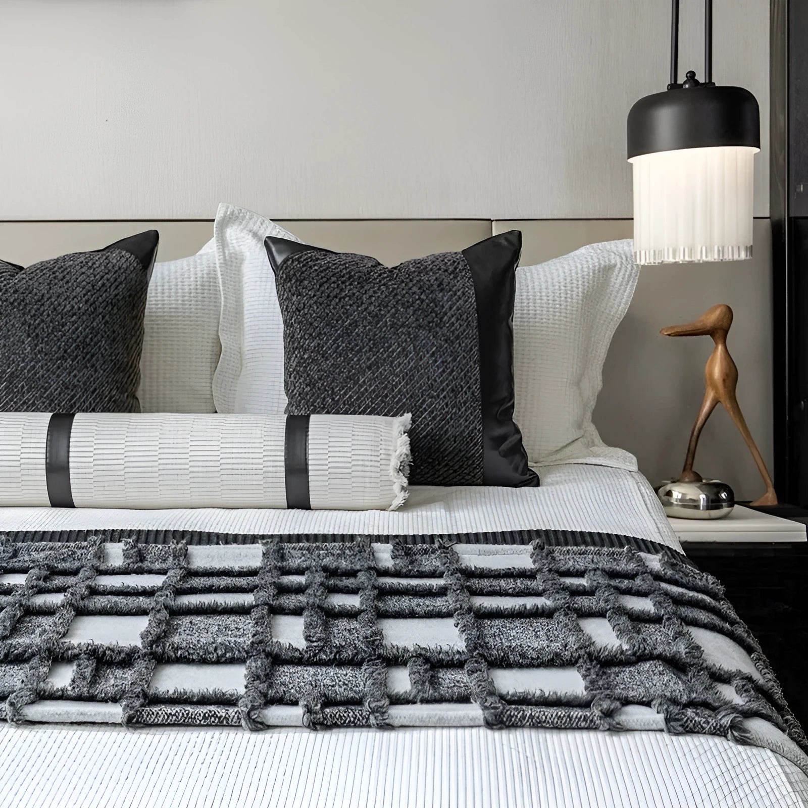 Modern grey and white plaid bed runner blanket set with a pillowcase and leather round pillow on a 1.5m bed.