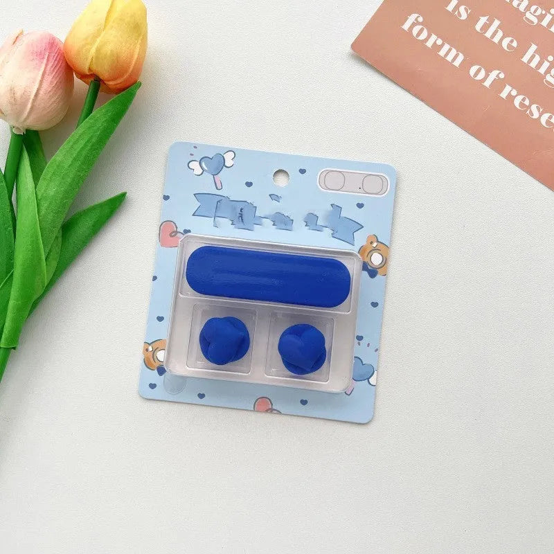 Cartoon magnetic protection data cable fixer in assorted colours on a desktop.