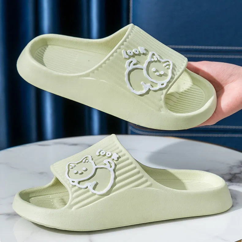 Green cat slippers with a thick EVA platform and non-slip sole on a wooden floor.