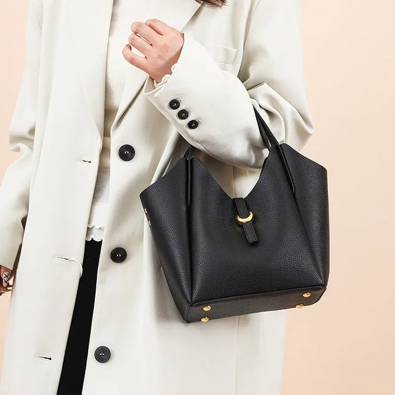 Genuine leather women's hand holding bucket bag in retro style with file compartment interior.