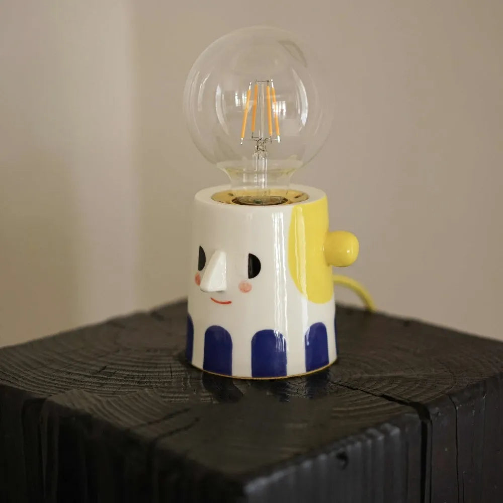 Handmade ceramic table lamp with ball headlight shade on wooden surface
