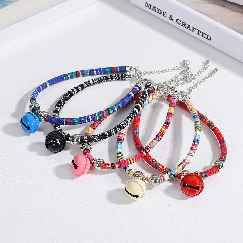 Coloured ethnic pattern adjustable pet collar for dogs and cats with a small metal bell attached.