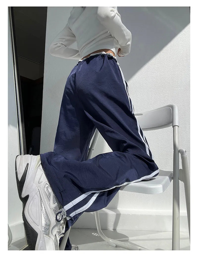 Navy blue loose straight leg drape pants with a low waist and thin fabric, laid flat.