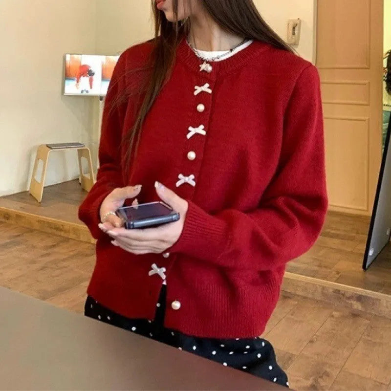 Women's solid colour cardigan sweater with a front bow decoration and pearl buttons.