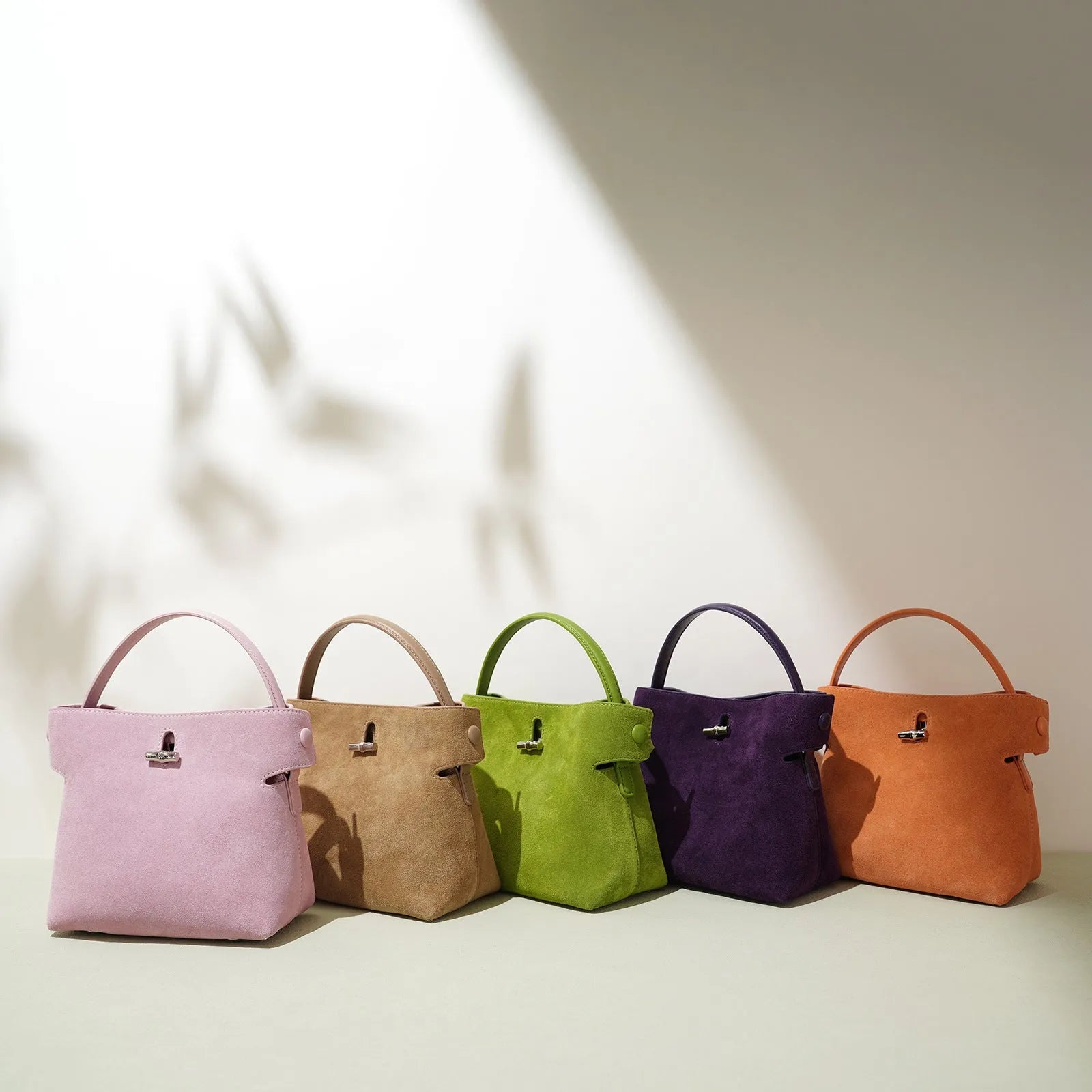 Women's mini messenger bag in matte cowhide with lock closure and bucket shape