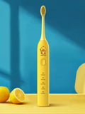 Yellow rechargeable electric toothbrush with small duck design, soft bristles, and a compact size.