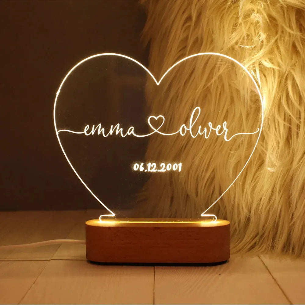 Custom engraved acrylic night light displaying personal names and a date, lit from a base LED.