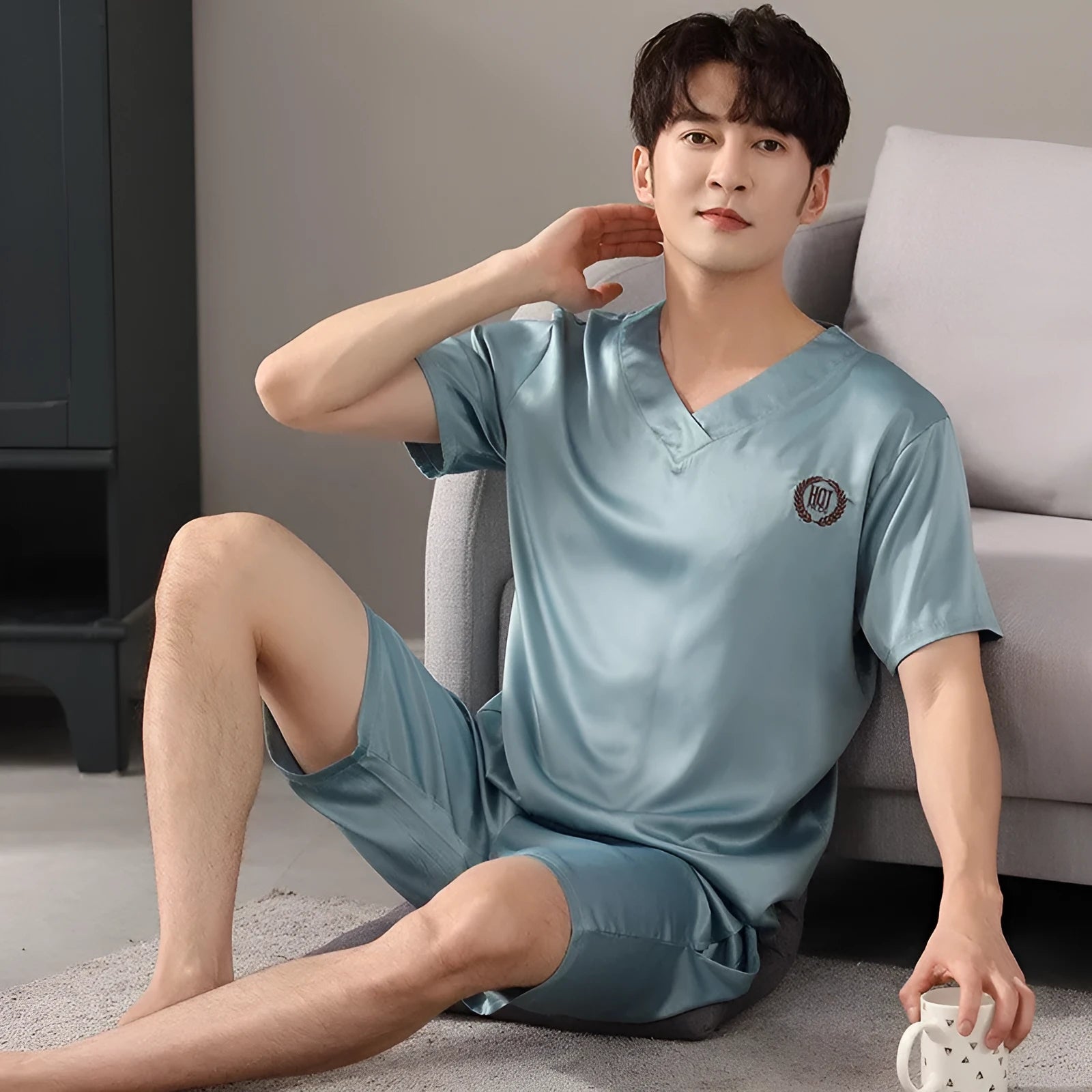 Man's loose blue ice silk short-sleeved pyjama shirt and matching shorts laid flat