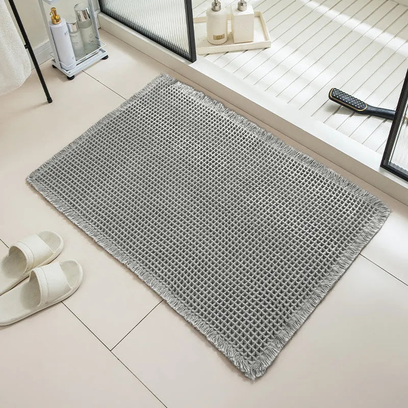 Square checkered pattern bathroom carpet on tiled floor in light grey colour.