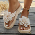 Plus size solid colour flip flop slippers with a flower detail on the upper, shown in beige.