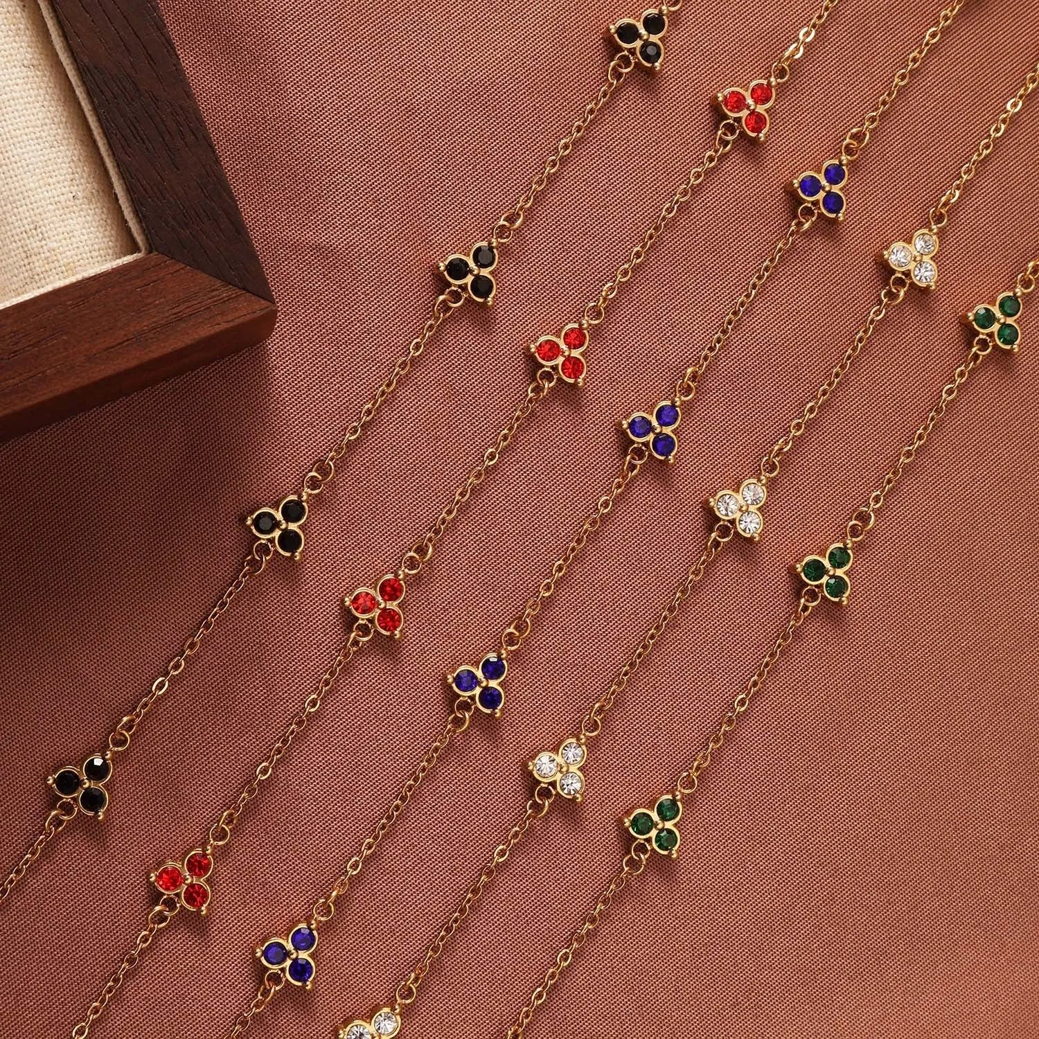 Women's geometric stainless steel bracelet with triangular diamond elements in gold or steel finish with coloured stones.