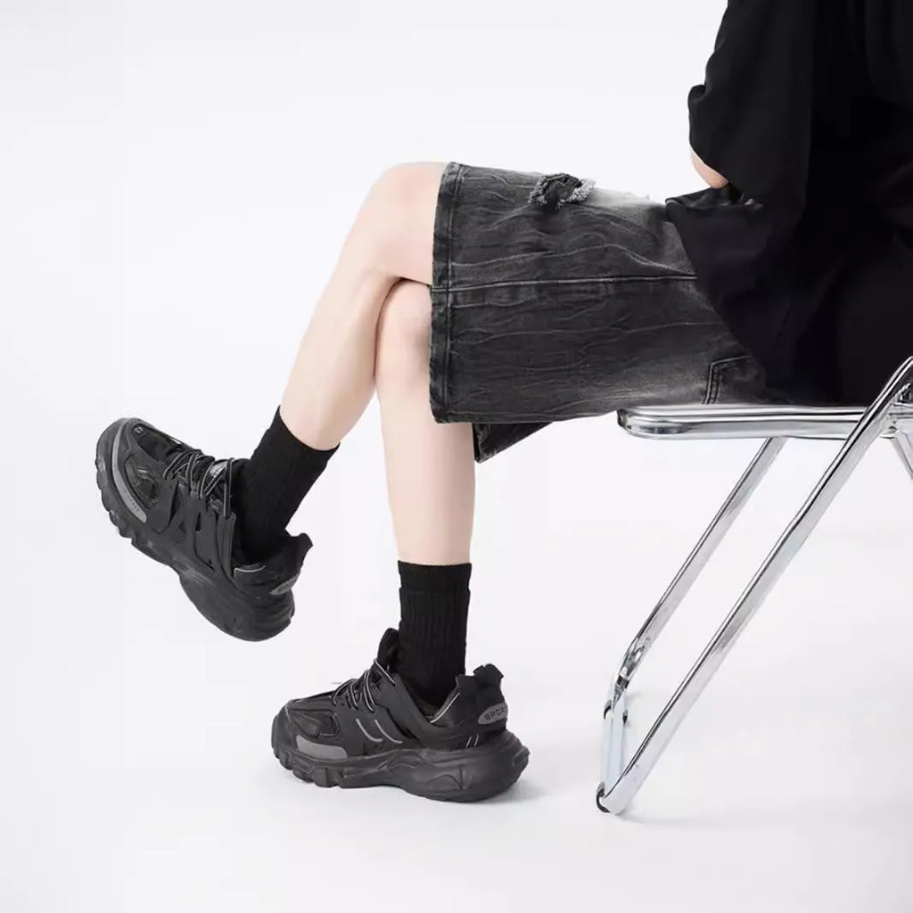 Men's ripped denim shorts with washed finish in black and blue colours showing loose fit design