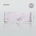 Mulberry silk sleep mask in black shown on a bed.