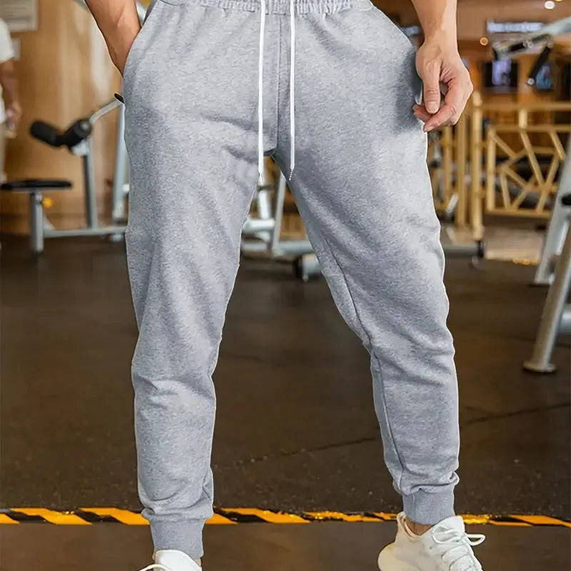 Men's loose-fit linen-look leisure trousers with a drawstring elastic waist in a light colour.