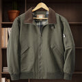 Men's beige washed cotton flight jacket on a hanger, showing its simple design and cotton fabric texture.