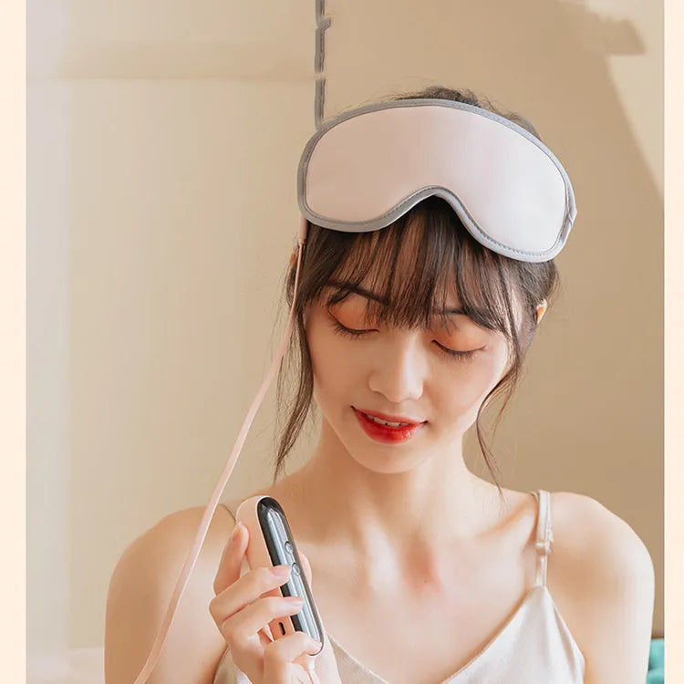 Pink and green portable eye SPA mask with USB cable, showing suede exterior and super fibre interior.