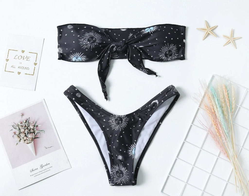 Black one-piece swimsuit with a bikini print pattern, featuring a split tube top and backless design.