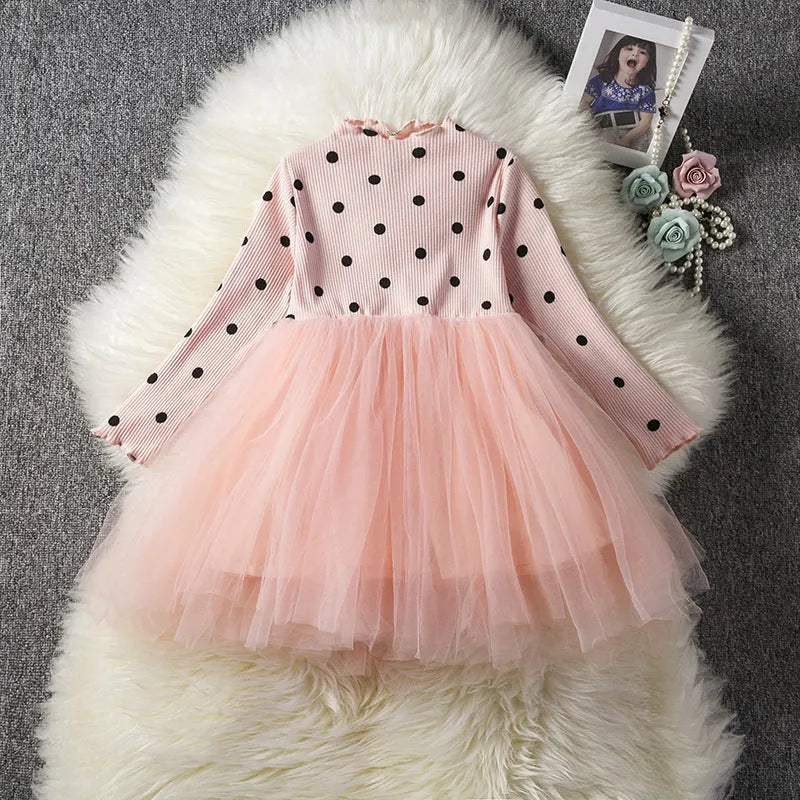 Baby girl in a long sleeve pink tutu dress with lace detailing on the sleeves.