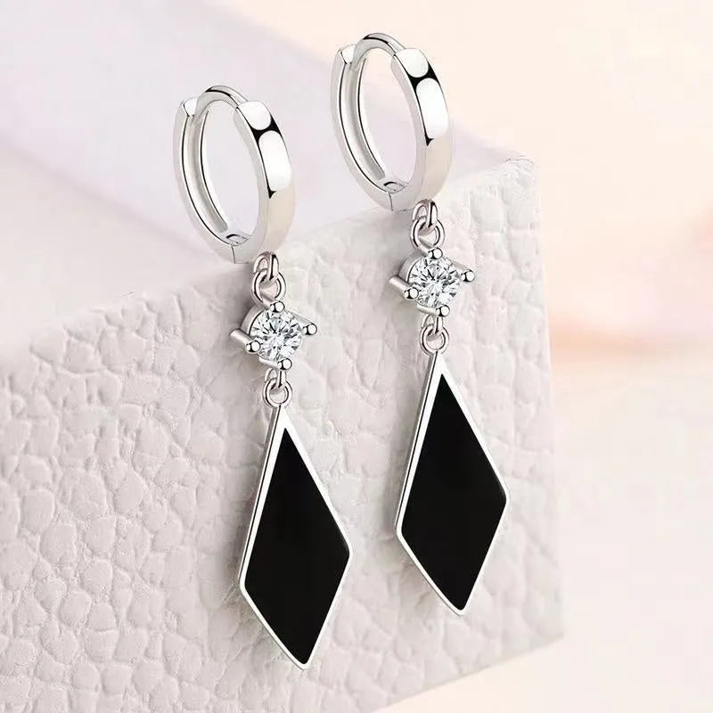 A pair of vintage silver diamond-shaped geometric clip-on earrings made from zinc alloy.