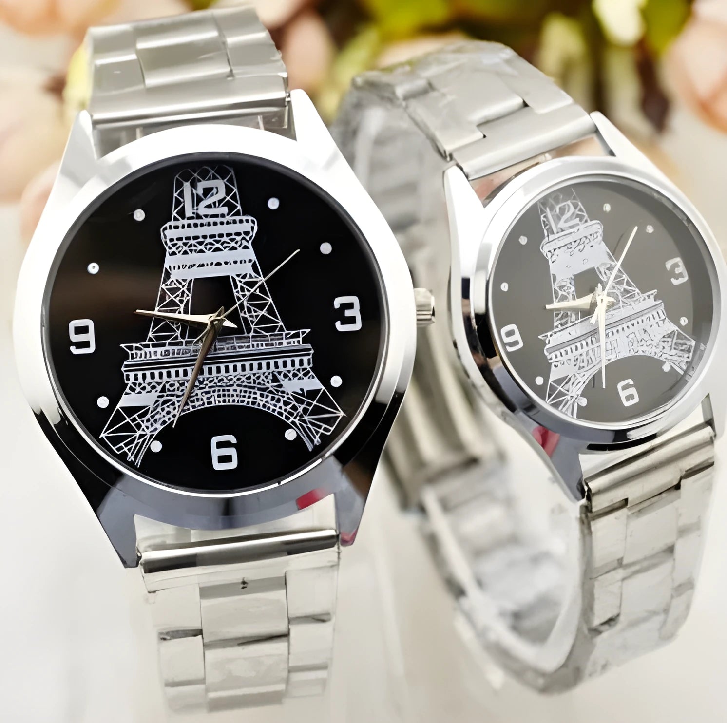 Silver Eiffel Tower wrist watch with stainless steel bracelet on a white dial.