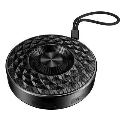 Compact black portable Bluetooth speaker on a table, showing its small size and design.
