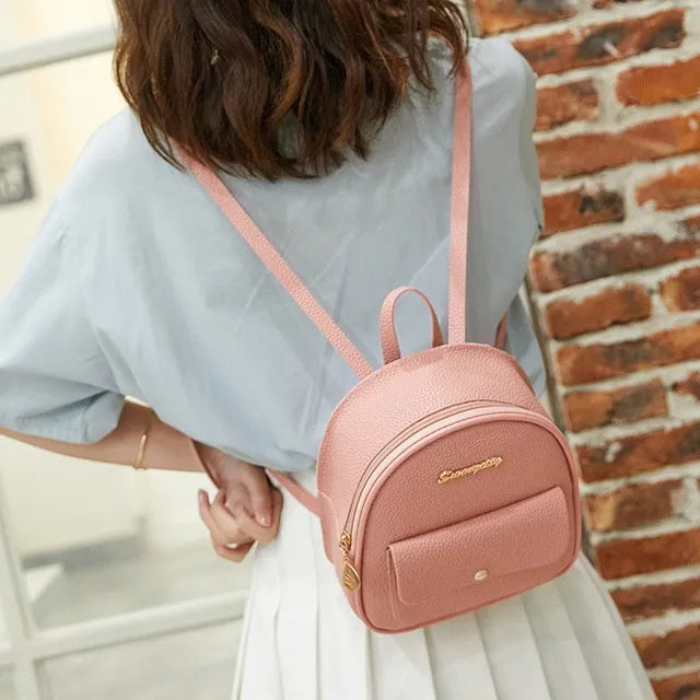 Small black PU women's backpack with zip closure shown as shoulder bag and backpack